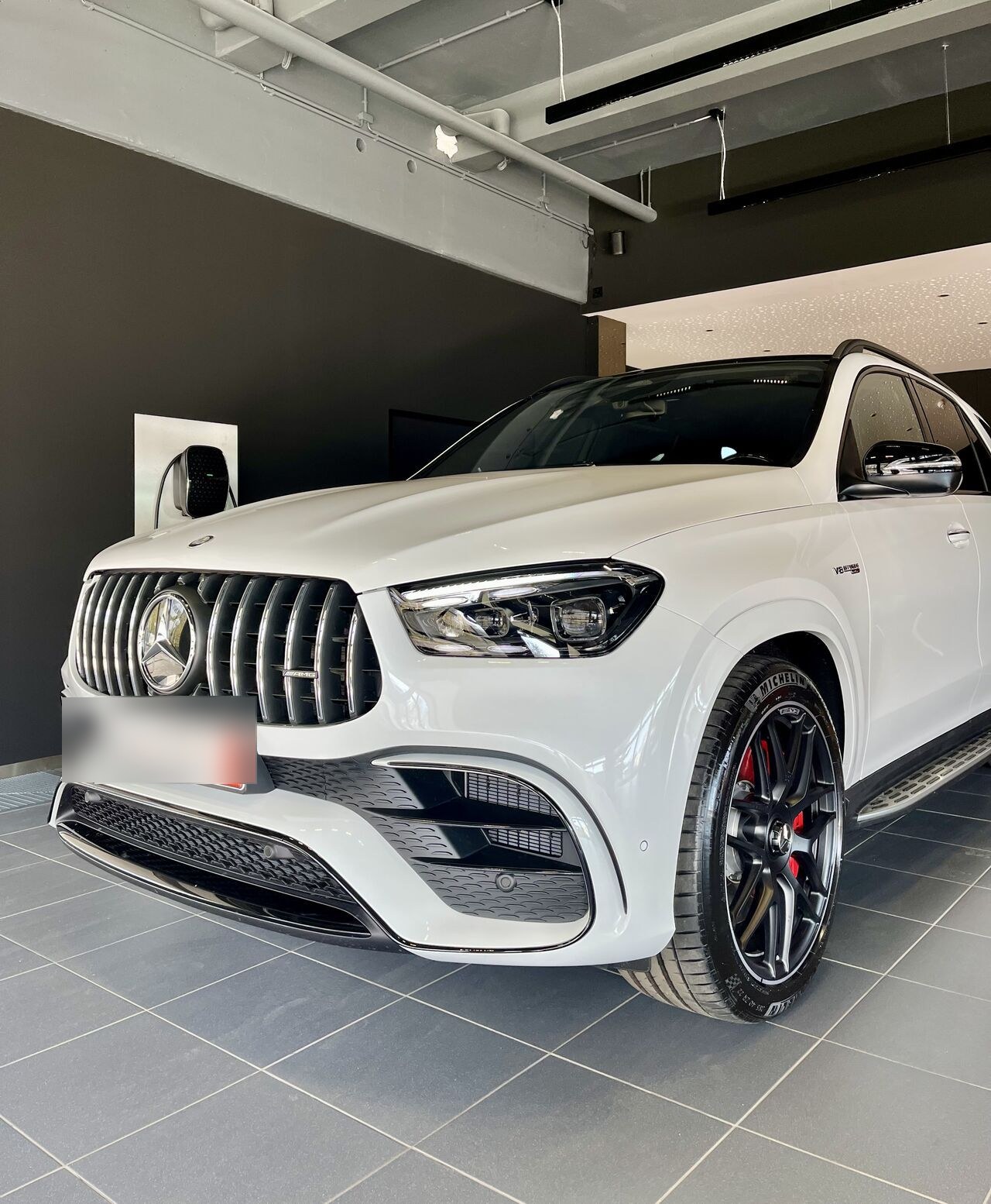 Weißer Mercedes-Benz GLE im dunklen Ausstellungsraum, persönliche Beratung mit Julian Kürten